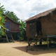 Examples of contemporary Cambodian homes. The house in the foreground is made from wood and thatch.